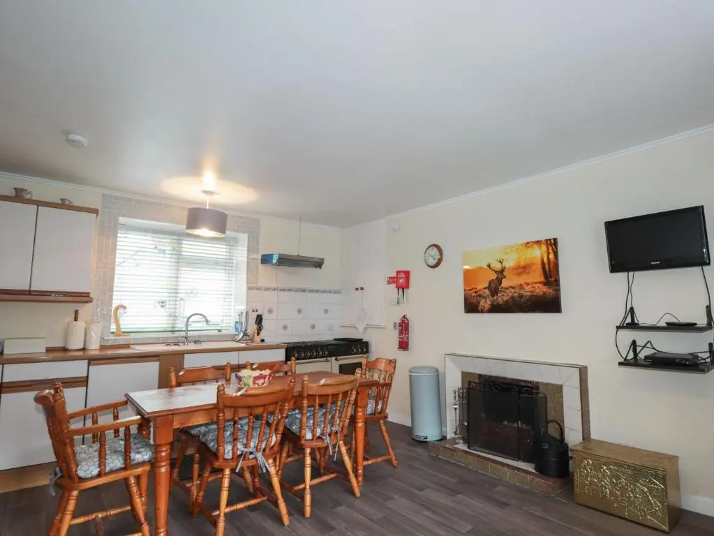 a kitchen and dining room with a table and chairs at Ivy House in Kingussie