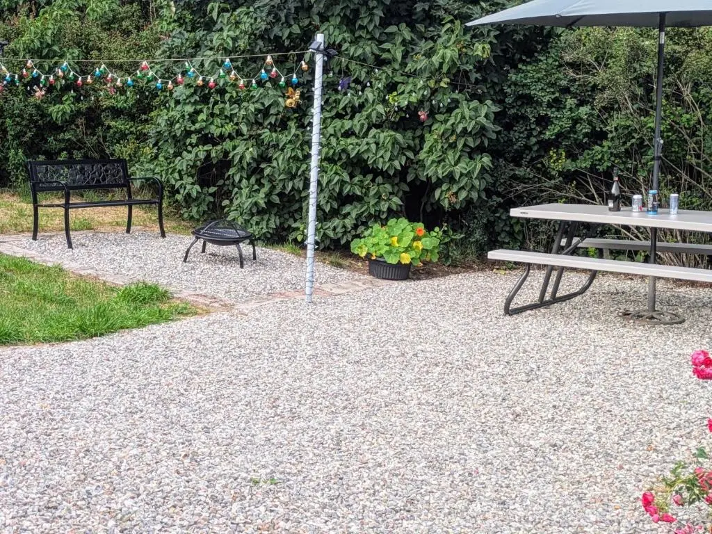a patio with a table and a bench and an umbrella at Ivy House in Kingussie