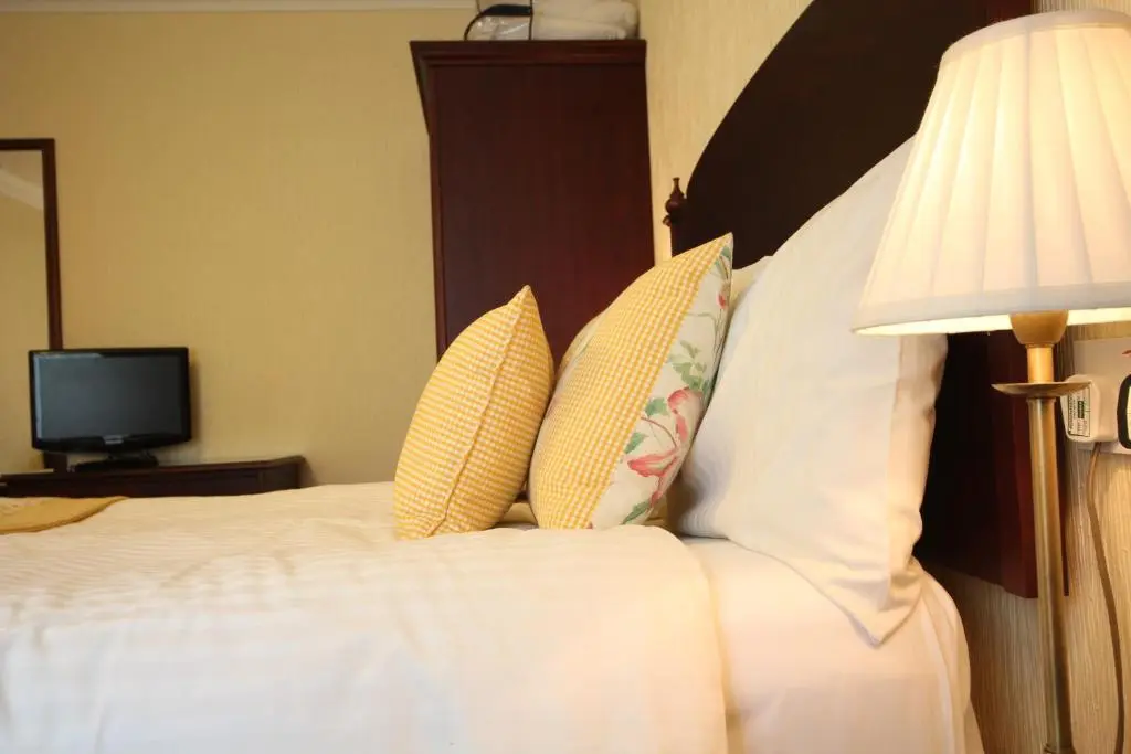 a bedroom with a bed with two pillows and a television at Strathburn Hotel Inverurie by Compass Hospitality in Inverurie