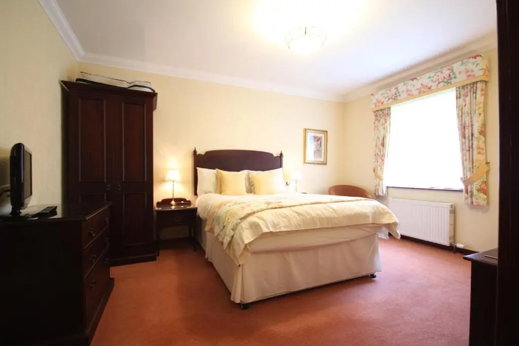 a bedroom with a large bed and a window at Strathburn Hotel Inverurie by Compass Hospitality in Inverurie