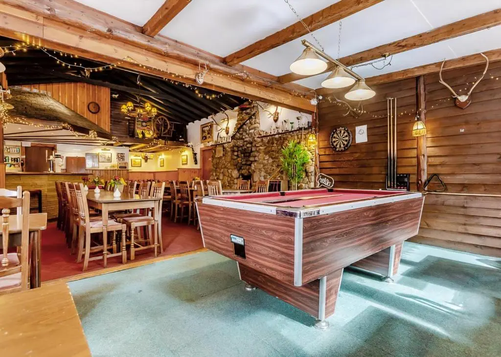 a restaurant with a pool table in a room at Delny Highland Lodges in Barbaraville