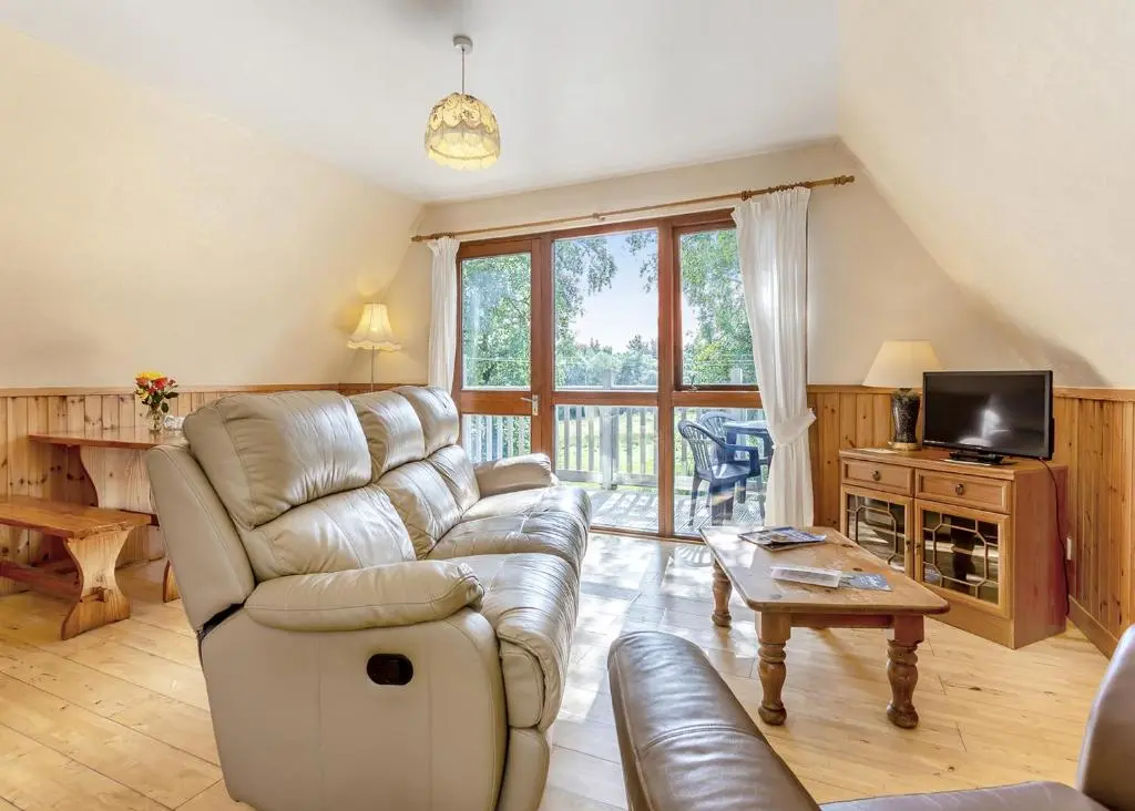 a living room with a couch and a tv at Delny Highland Lodges in Barbaraville
