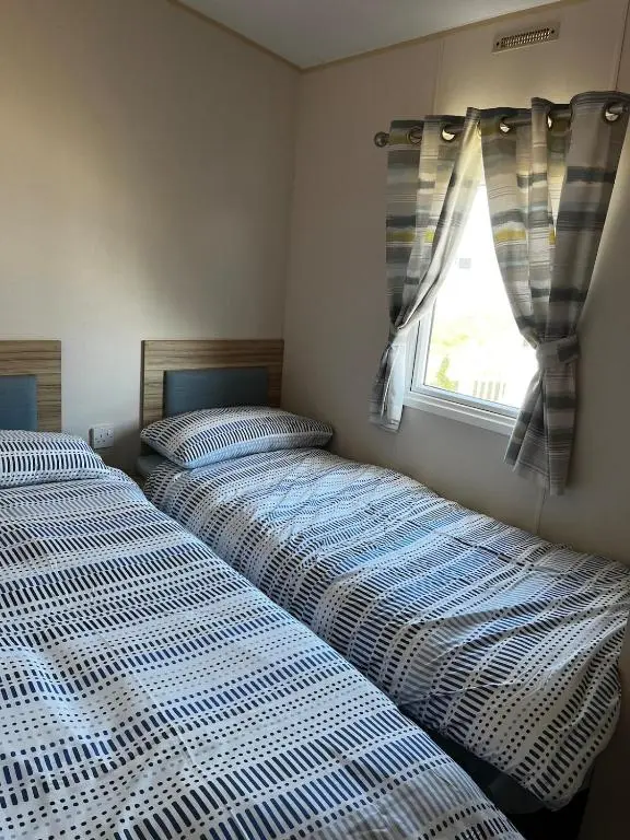 two beds sitting next to each other in a bedroom at Sand Dollar, Silver Sands Holiday Park in Lossiemouth