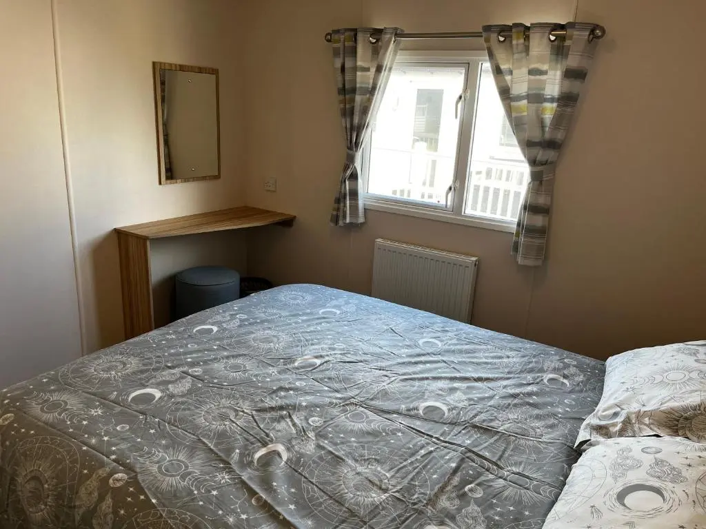 a bedroom with a bed and a window at Sand Dollar, Silver Sands Holiday Park in Lossiemouth