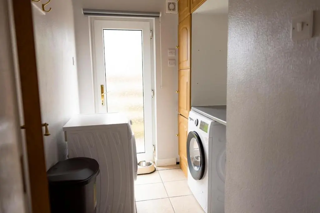 a laundry room with a washing machine and a window at Wynstone Cottage, Speyside in Fochabers