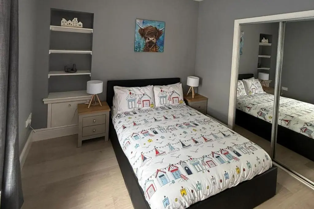 a bedroom with two beds and a mirror at 1 Bed Flat - Sleeps 2 - Parking - Wifi in Nairn