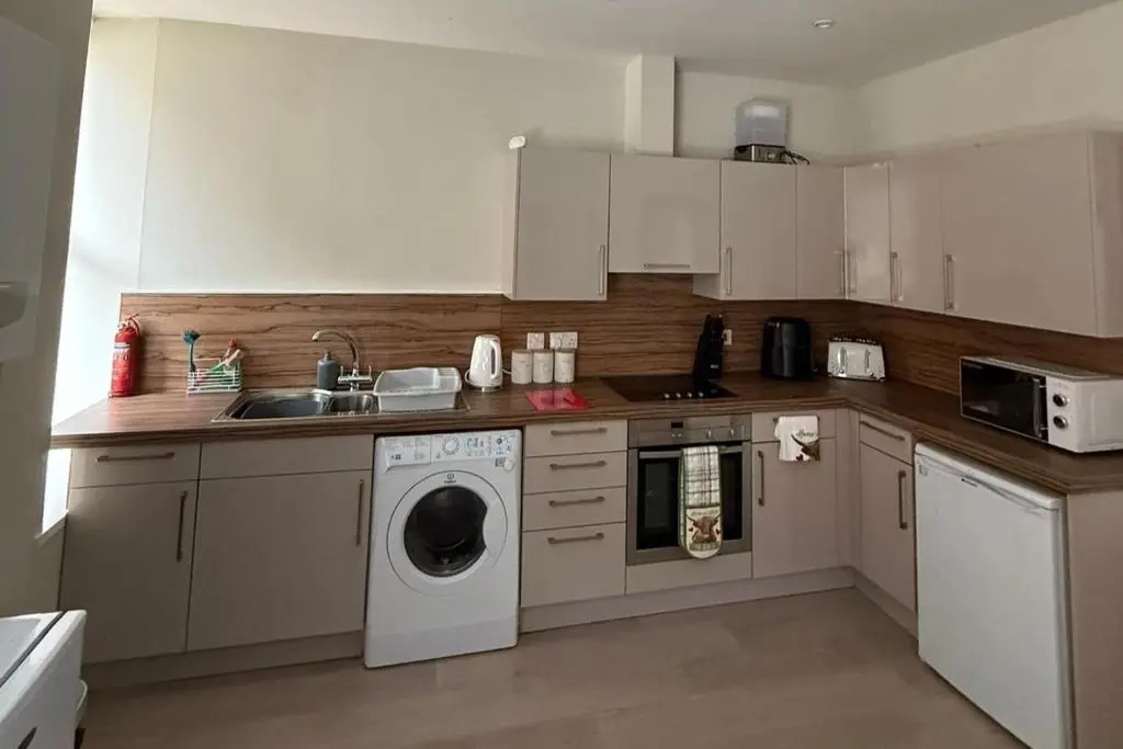 a kitchen with a washing machine and a sink at 1 Bed Flat - Sleeps 2 - Parking - Wifi in Nairn