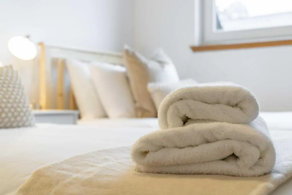 a stack of towels sitting on top of a bed at King Cosy 2 Bedroom Apartment - Inverness in Inverness