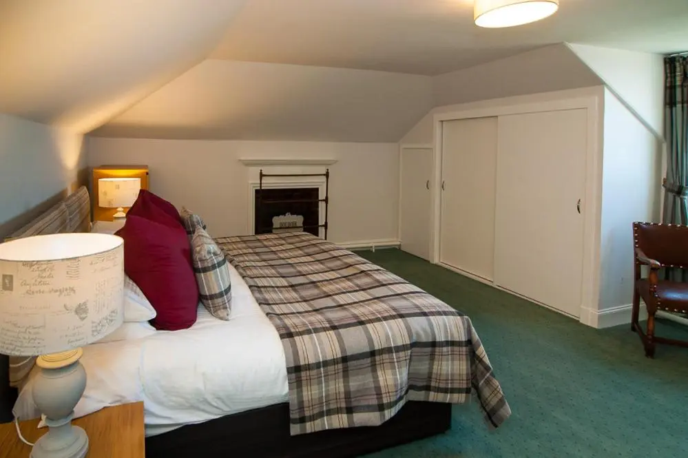 a hotel room with a bed with red pillows at The Penthouse Self Catering in Nairn