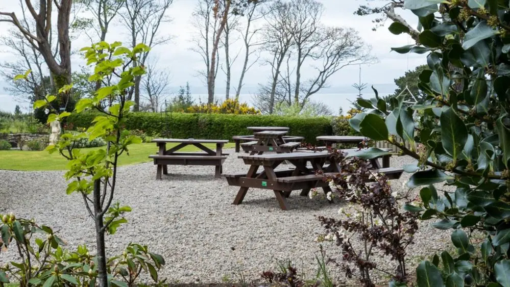 a group of picnic tables and benches in a park at The Penthouse Self Catering in Nairn