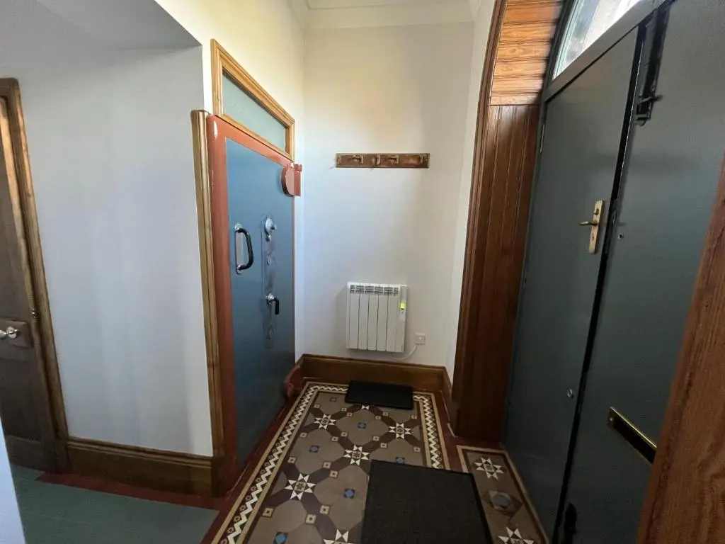 a hallway with a blue door and a rug at Bank House apartment in Fort Augustus