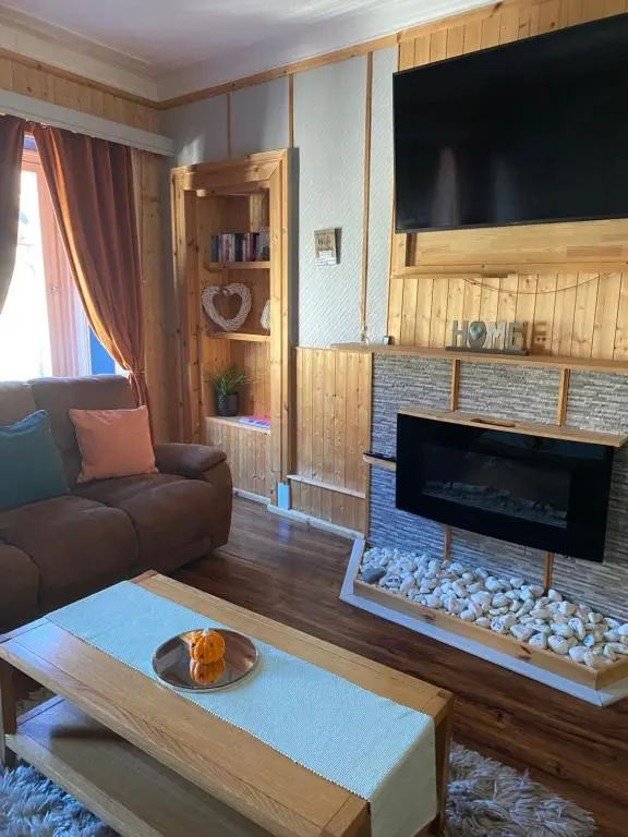 a living room with a couch and a fireplace at Georges holiday apt the blue suite in Inverness