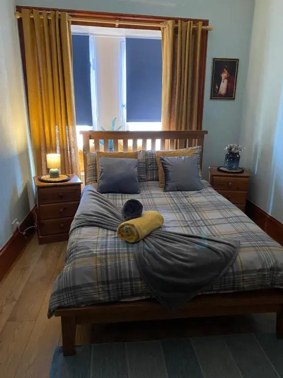 a bedroom with a bed with a large window at Georges holiday apt the blue suite in Inverness