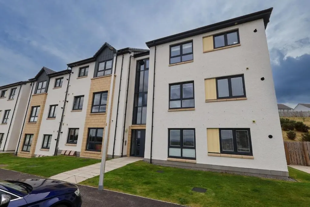 an apartment building with a car parked in front of it at Inverness Haven: Bright 2B/2B with Scenic Views in Inverness