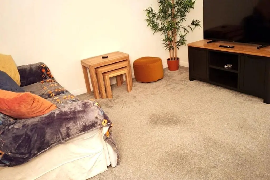 a living room with a couch and a tv and a table at Inverness Haven: Bright 2B/2B with Scenic Views in Inverness