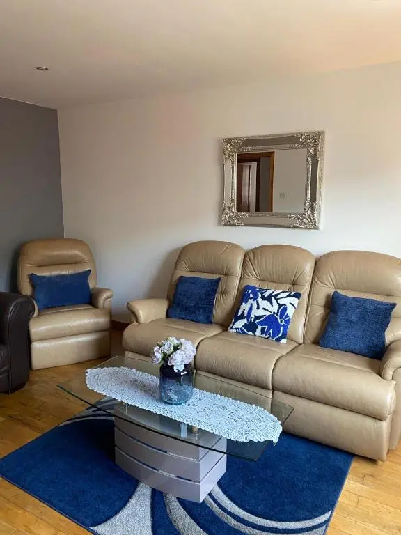 a living room with a couch and a table at Georges 1Faraline court Apartment in Inverness