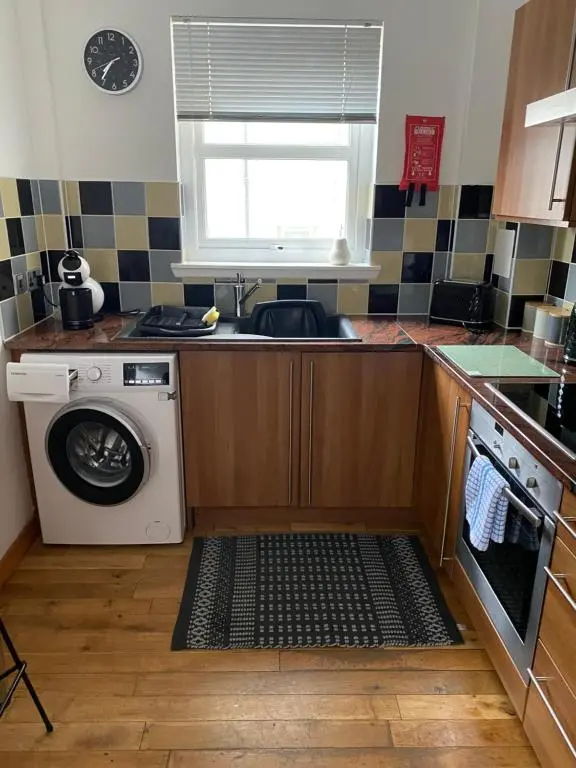 a kitchen with a sink and a washing machine at Faraline in Inverness