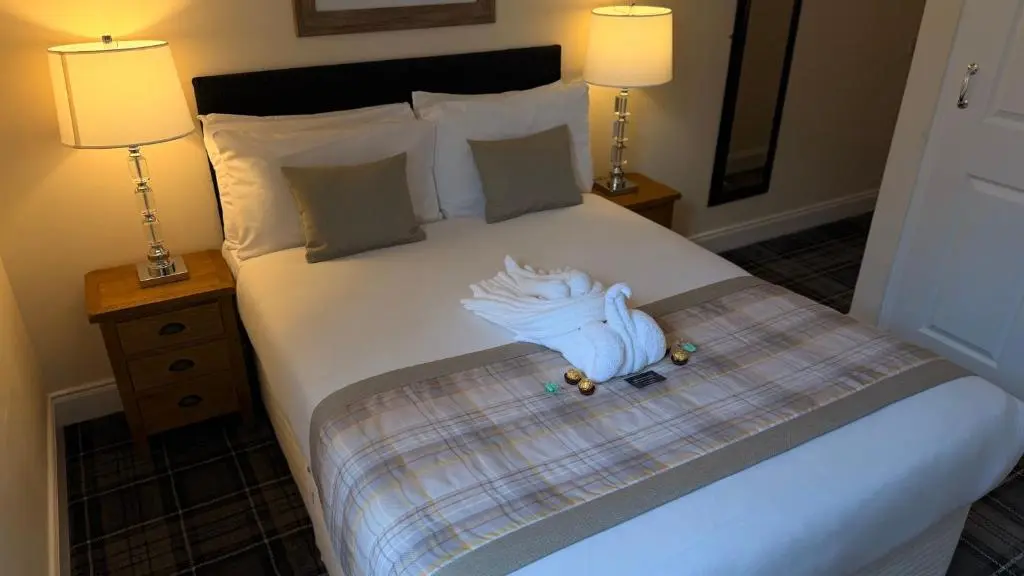 a bedroom with a bed with two lamps on it at The Waverley Guest House in Inverness