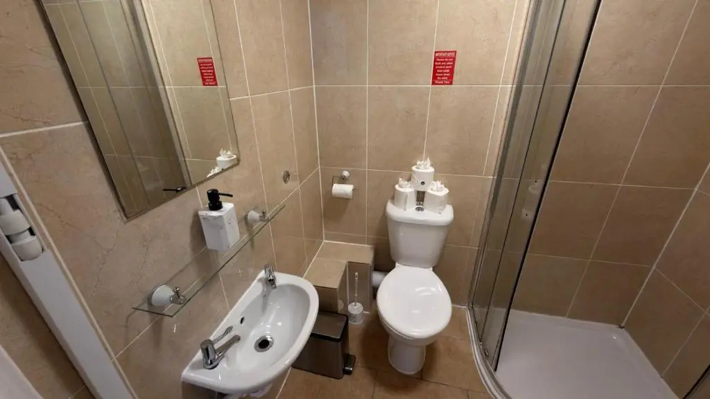 a bathroom with a toilet and a sink and a shower at The Waverley Guest House in Inverness
