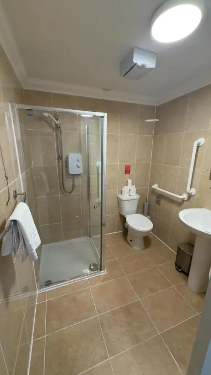 a bathroom with a shower and a toilet and a sink at The Waverley Guest House in Inverness