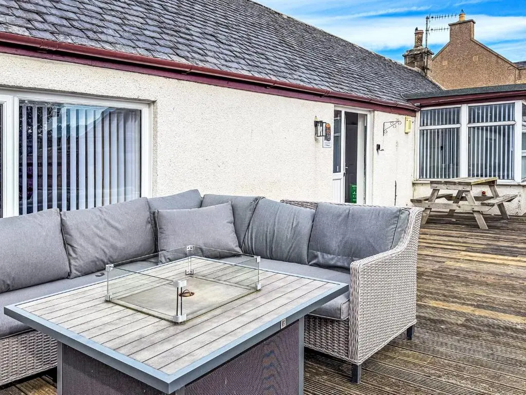 a couch on a deck with a table at Holiday Home Gordonstoun Cottage by Interhome in Elgin