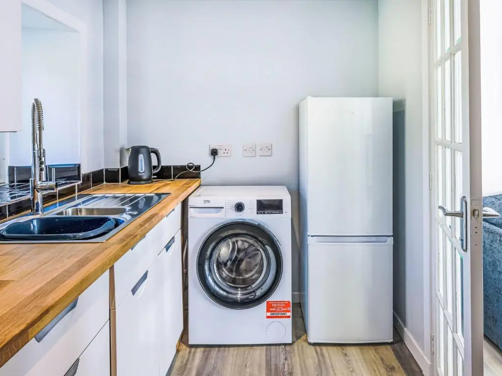 a kitchen with a refrigerator and a washing machine at Holiday Home Gordonstoun Cottage by Interhome in Elgin