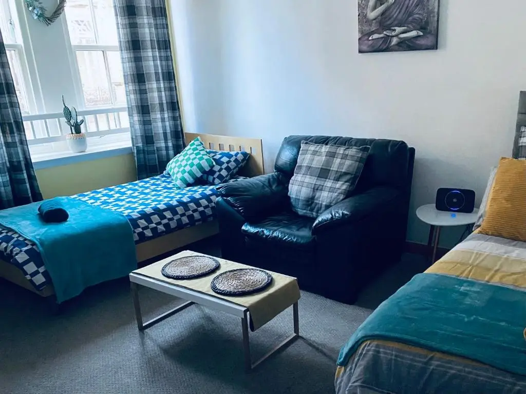 a living room with a couch and a chair at Church st 48B in Inverness