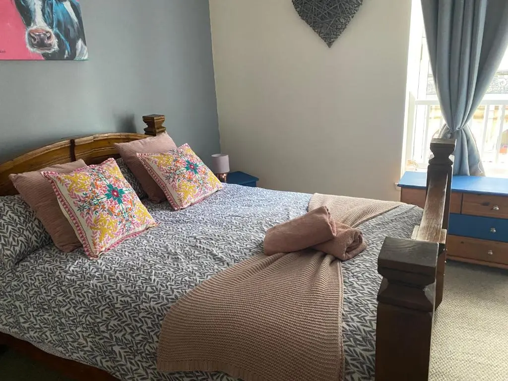 a bedroom with a large bed with colorful pillows at Church st 48B in Inverness