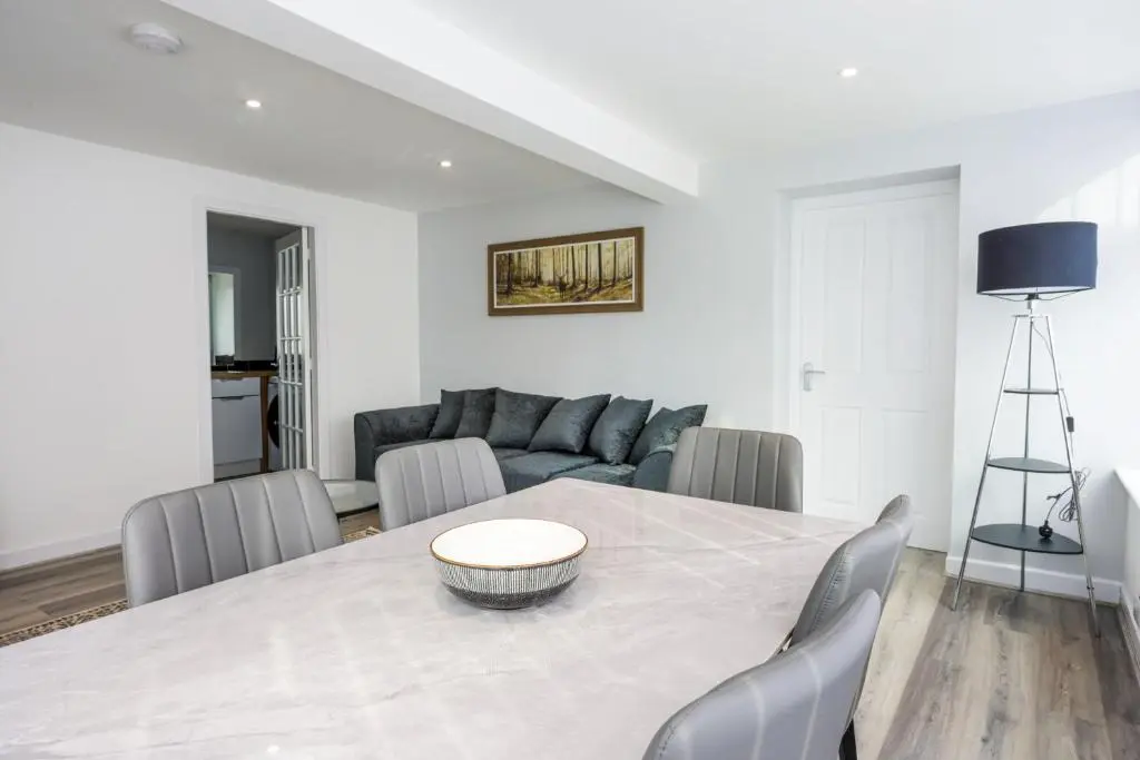 a dining room table with chairs and a couch at Duffus Nights in Duffus