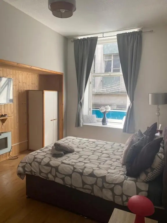 a bedroom with a bed and a large window at Lombard in Inverness
