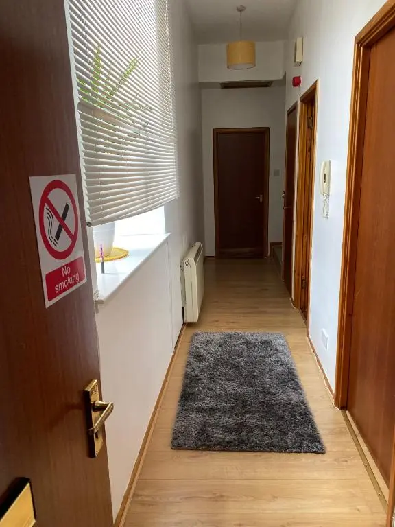 a hallway with a door and a rug on the floor at Lombard in Inverness