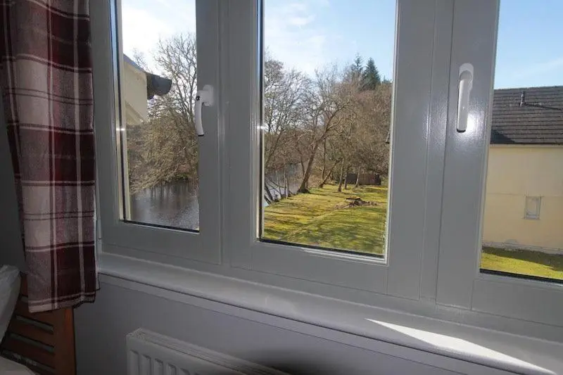a window with a view of a river and trees at Cottage 7 - Skye Cottage in Fort Augustus