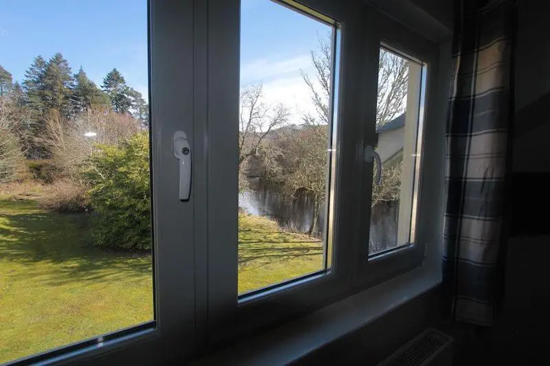 a window with a view of a river in a yard at Cottage 7 - Skye Cottage in Fort Augustus