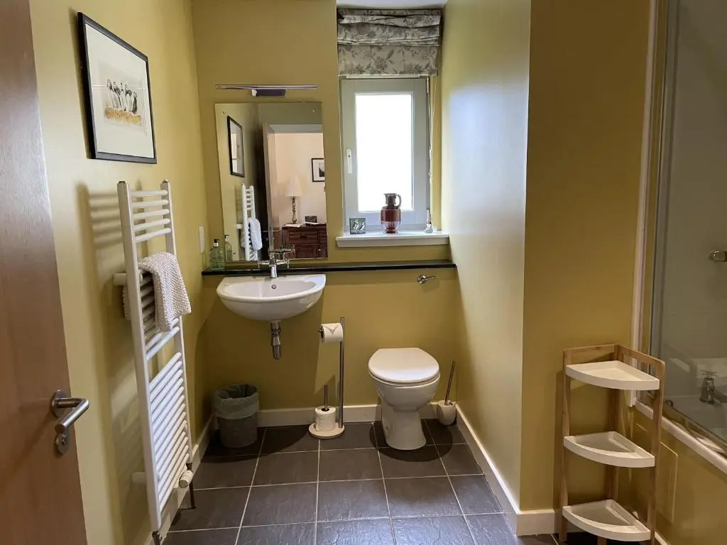 a bathroom with a sink and a toilet and a mirror at Cottage 7 - Skye Cottage in Fort Augustus