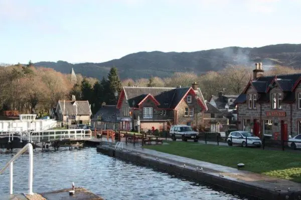 a group of houses next to a body of water at Cottage 7 - Skye Cottage in Fort Augustus