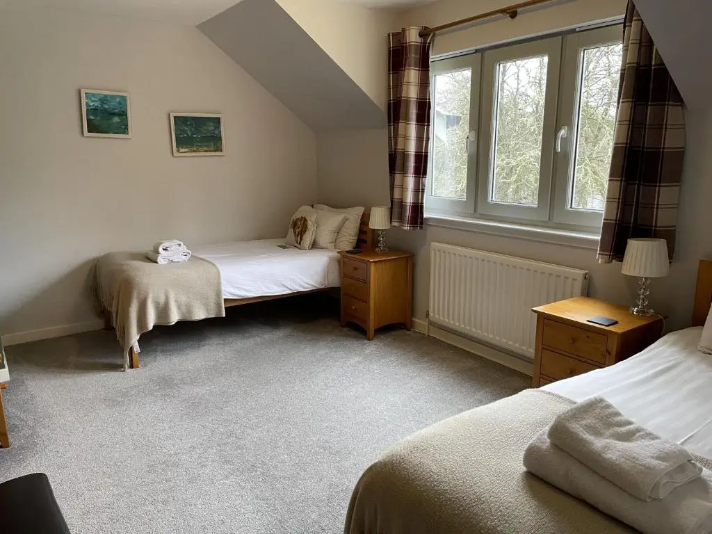 a bedroom with two beds and a window at Cottage 7 - Skye Cottage in Fort Augustus