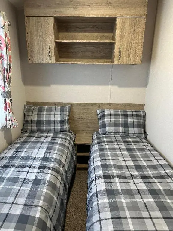 two beds sitting next to each other in a room at Aurora Sky in Lossiemouth