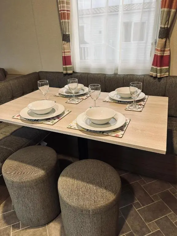 a table with plates and wine glasses on it at Aurora Sky in Lossiemouth