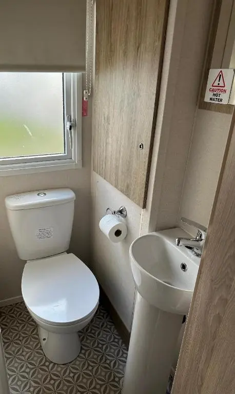 a small bathroom with a toilet and a sink at Aurora Sky in Lossiemouth