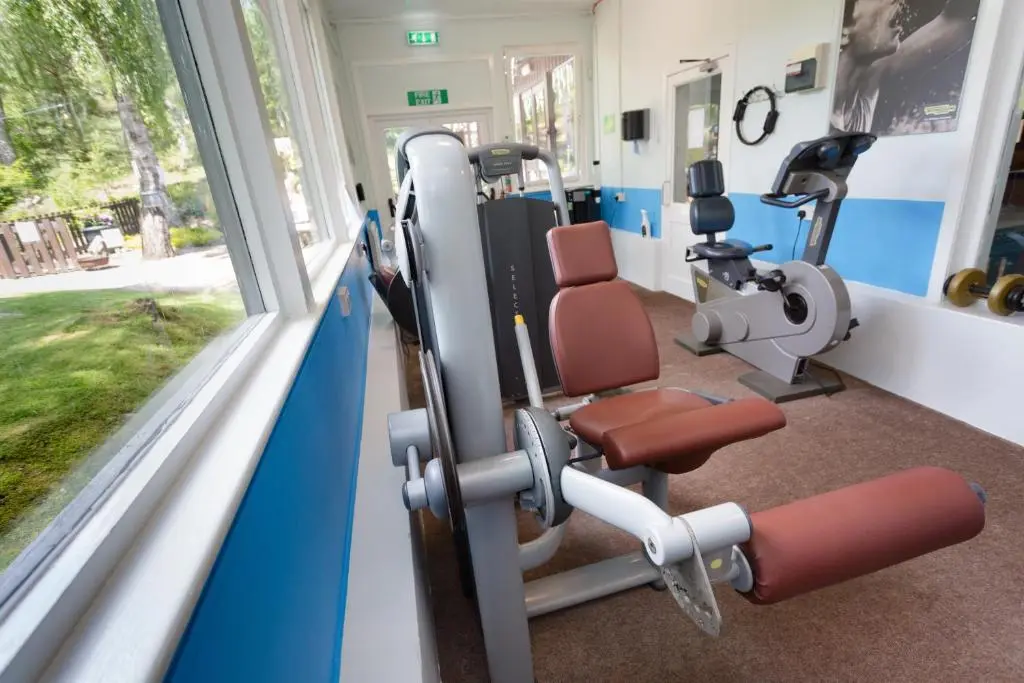 a gym with a bench and tread machines at Macdonald Lochanhully Resort in Aviemore