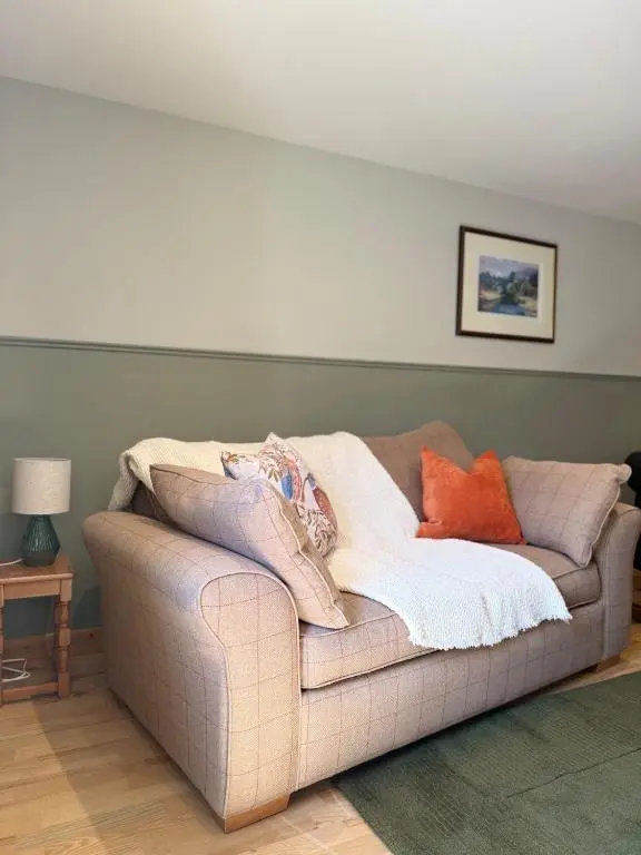 a couch with pillows on it in a living room at Friar's Rest - Beauly Village in Beauly