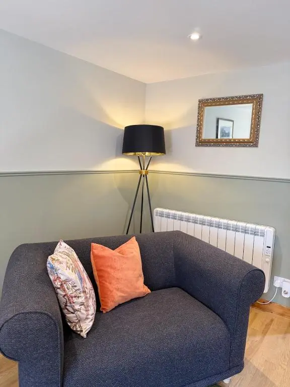 a blue couch in a living room with a lamp at Friar's Rest - Beauly Village in Beauly