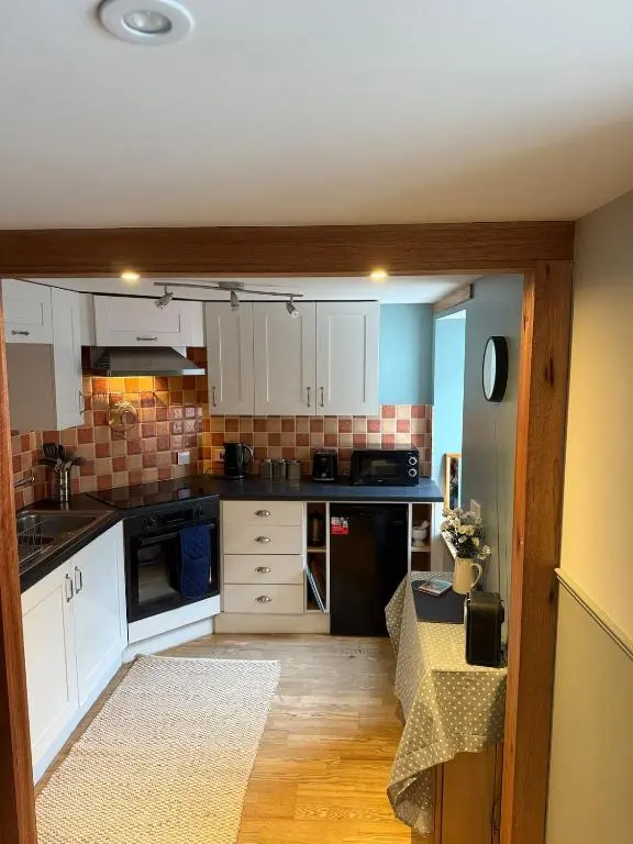 a kitchen with white cabinets and a counter top at Friar's Rest - Beauly Village in Beauly