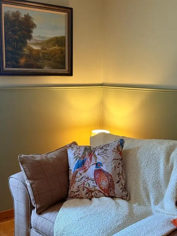 a living room with a couch and a painting on the wall at Friar's Rest - Beauly Village in Beauly
