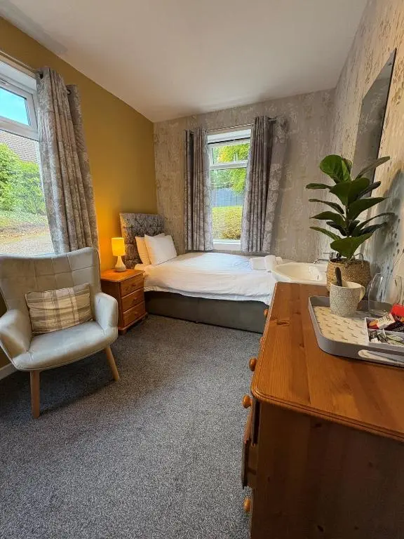 a bedroom with a bed and a chair and a desk at Cannich at RHA in Dalneigh
