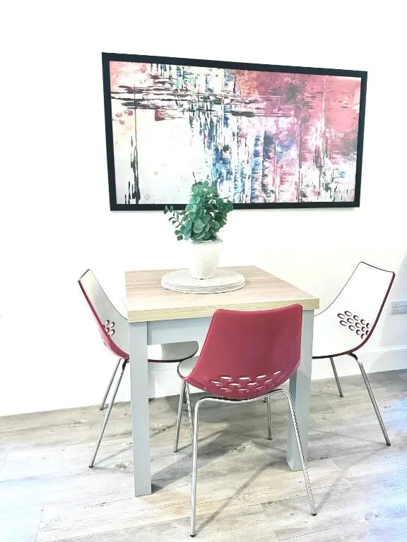 a table with two chairs and a vase on it at Picturesque Tornagrain Apartment 2bed Free Parking WiFi - Near Inverness Airport