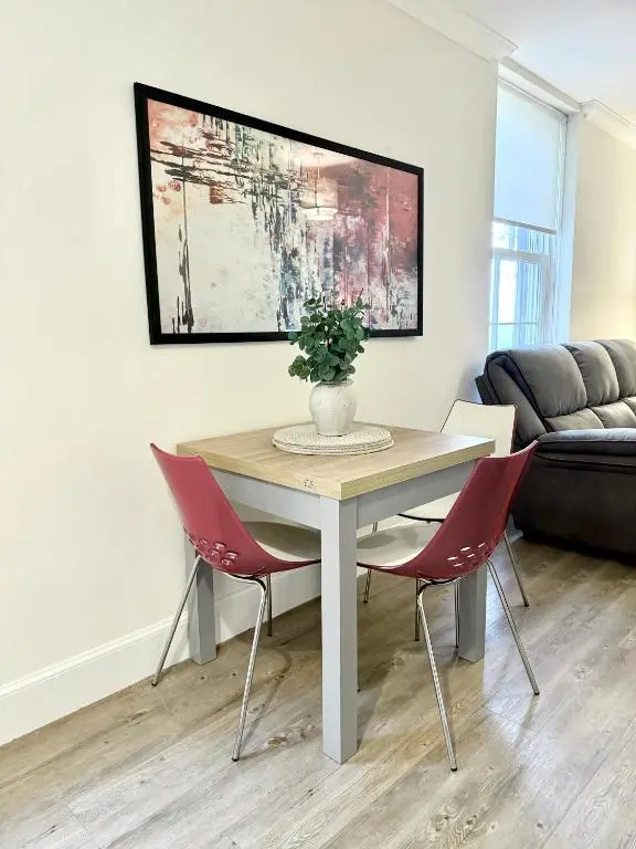 a dining room with a table and chairs and a couch at Picturesque Tornagrain Apartment 2bed Free Parking WiFi - Near Inverness Airport