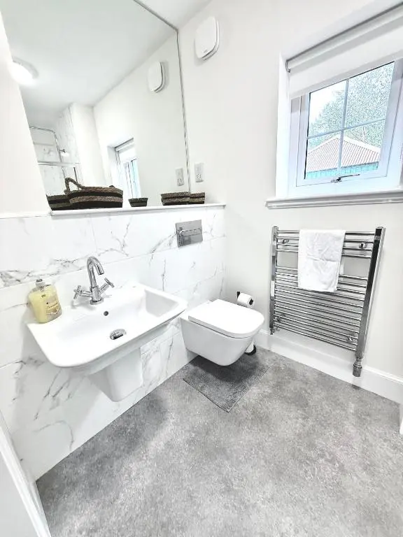 a white bathroom with a sink and a toilet at Picturesque Tornagrain Apartment 2bed Free Parking WiFi - Near Inverness Airport
