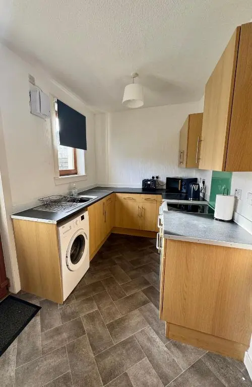 a kitchen with a washer and dryer in it at Bruce Gardens Home in Inverness
