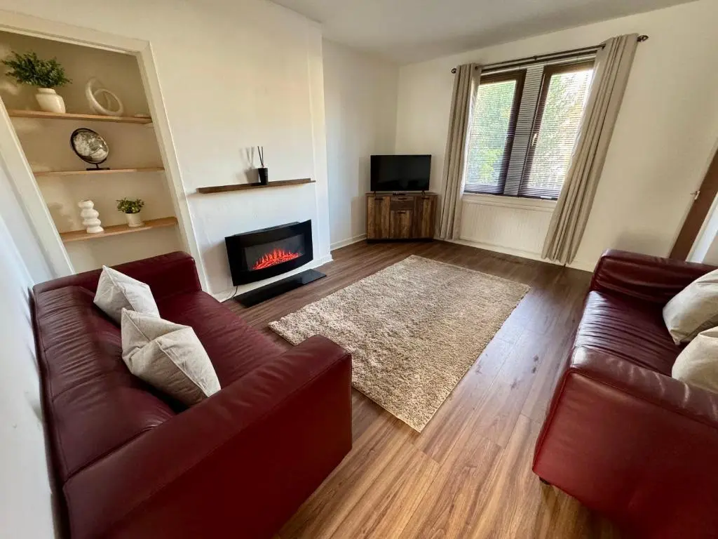 a living room with a couch and a fireplace at Bruce Gardens Home in Inverness